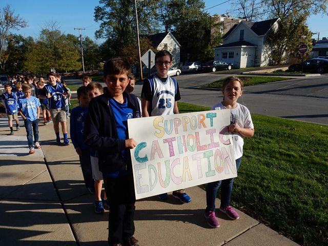 Group of St Pets students walking and holding a Support Catholic Education sign
